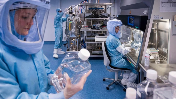 Employees in cleanroom suits test the procedures for the manufacturing of the messenger RNA (mRNA) for the Covid-19 vaccine at the new manufacturing site of German company BioNTech