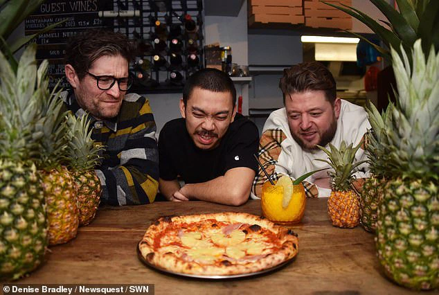 On the left, Francis Woolf, Quin Jianoran, and Felix Rehberg from Lupa Pizza in Norwich, Norfolk, are gazing at a Hawaiian pizza with evident distaste.