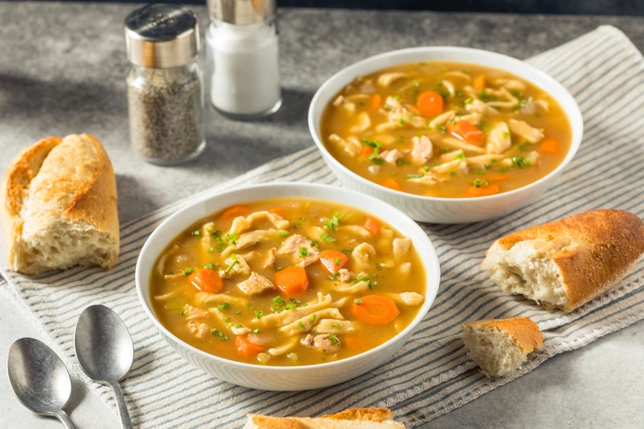 two bowls of shortcut chicken noodle soup with bread