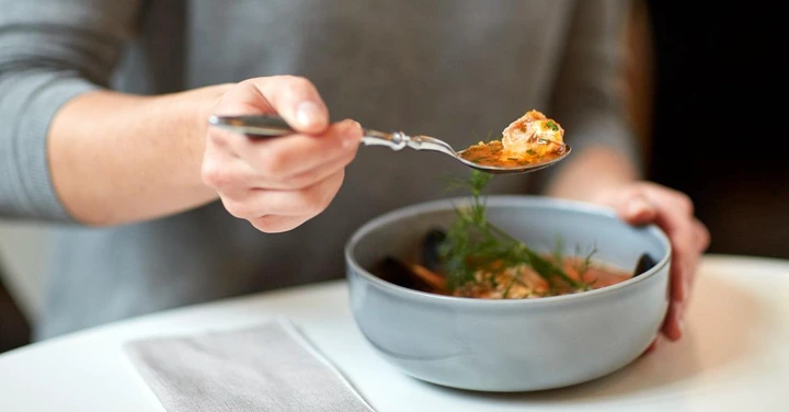 woman eating fish soup
