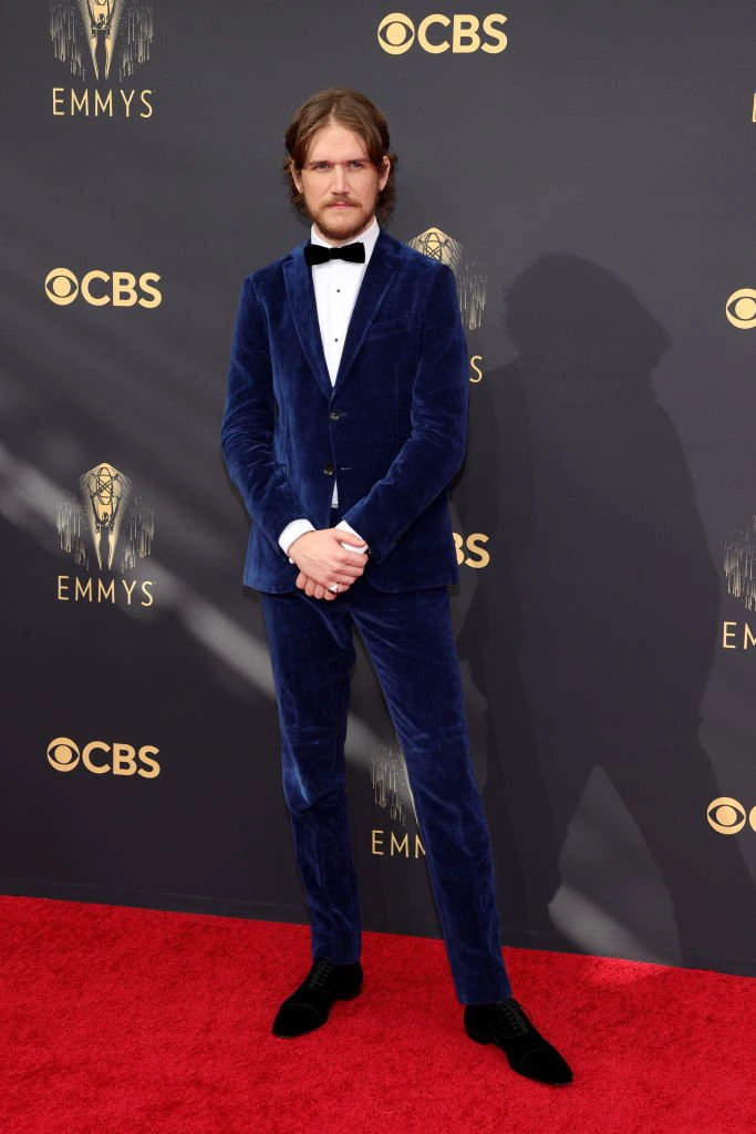 Bo in a velvet suit and bow tie on a red carpet at a celebrity event