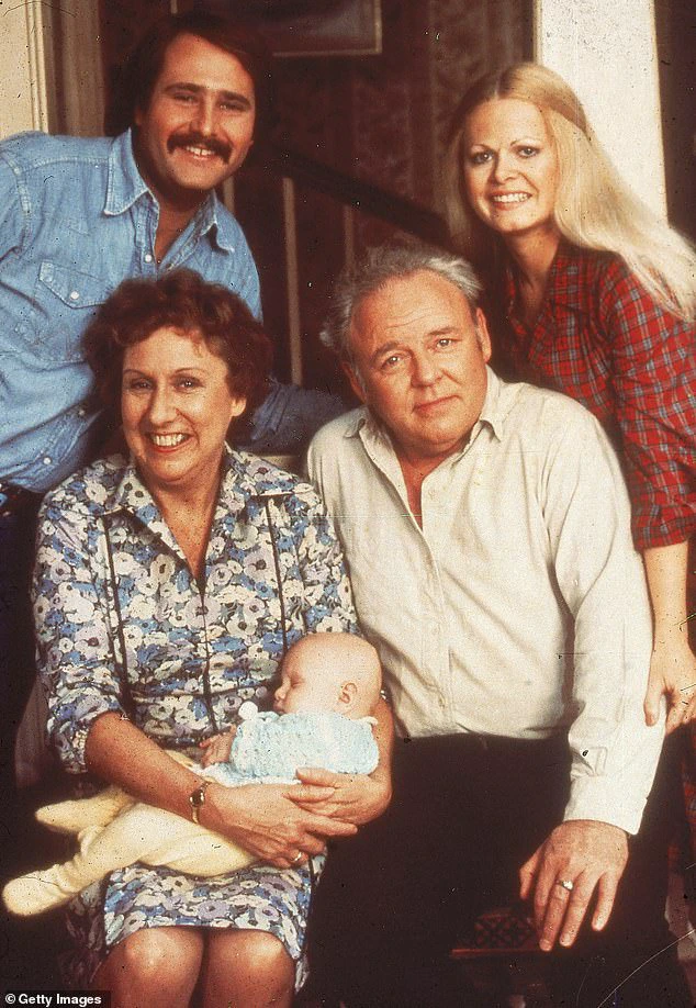 In a 1976 promotional photo for All In The Family, Rob Reiner and Struthers are positioned at the top (left to right), while Jean Stapleton is seen holding Corey M Miller, alongside Carroll O'Connor, at the bottom (left to right).