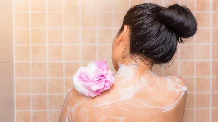 Portrait of beautiful woman taking shower with bath sponge., Health skincare concept.