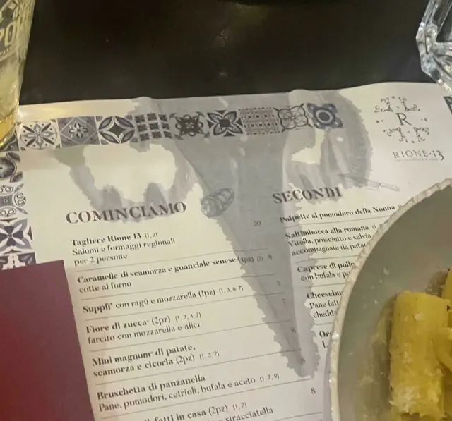 Menu with optical illusion; glass shadow creates a T-rex shape, illustrating things look like other things.