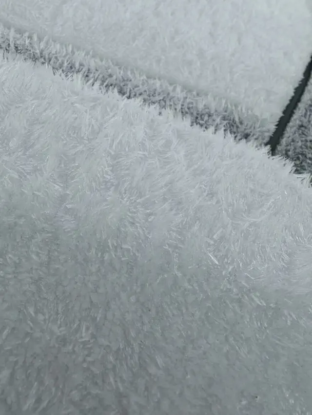 Close-up of a white carpet that looks like snow, highlighting things that look like other things.