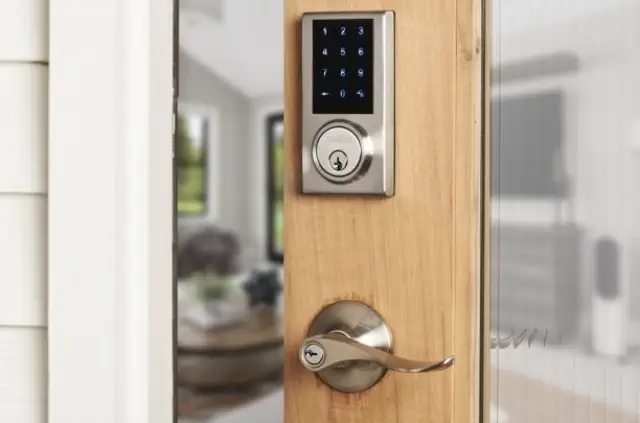 Smart lock with a touchscreen keypad on a wooden door, featured in a shopping article