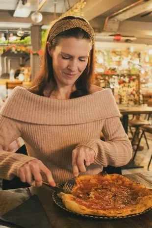 Francesca enjoyed a meal of pizza and pasta, accompanied by a glass of wine.
