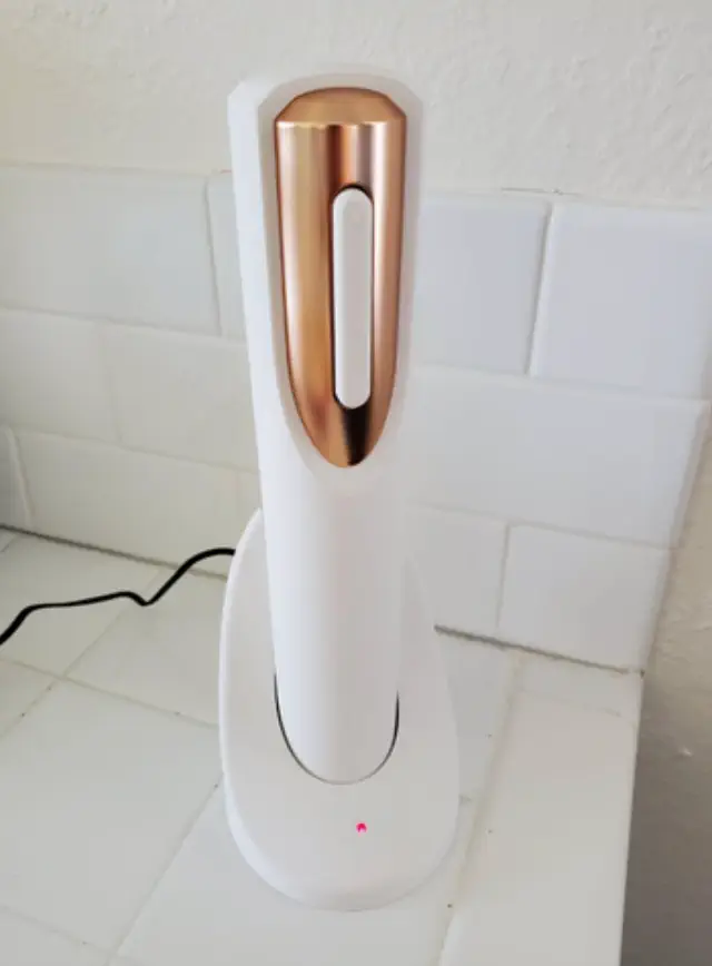 Cordless automatic wine opener with a charging base on a white countertop