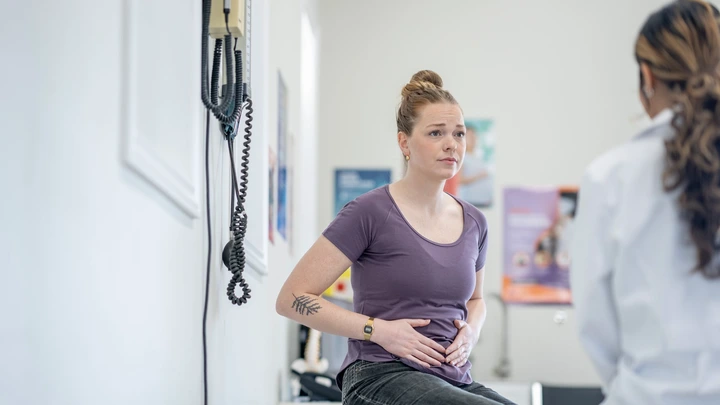 Woman at the doctor with stomach pain