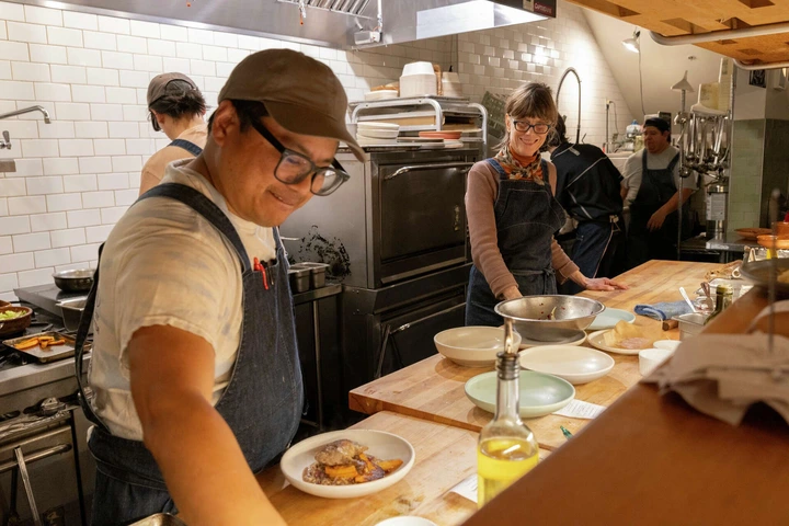 Kelsie Kerr, the chef and owner of Regular Menu, right, chats with Carlo Espinas as he plates an order in Berkeley, Calif., on Friday, Jan. 03, 2025.