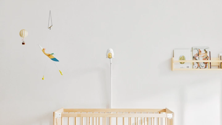 The CuboAi Smart Baby Monitor 3 mounted over a crib in a minimalist nursery