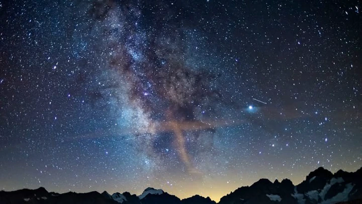 The Milky Way arch starry sky on the Alps, Massif des Ecrins, Briancon Serre Chevalier ski resort, France. Panoramic view high mountain range and glaciers, astro photography, stargazing