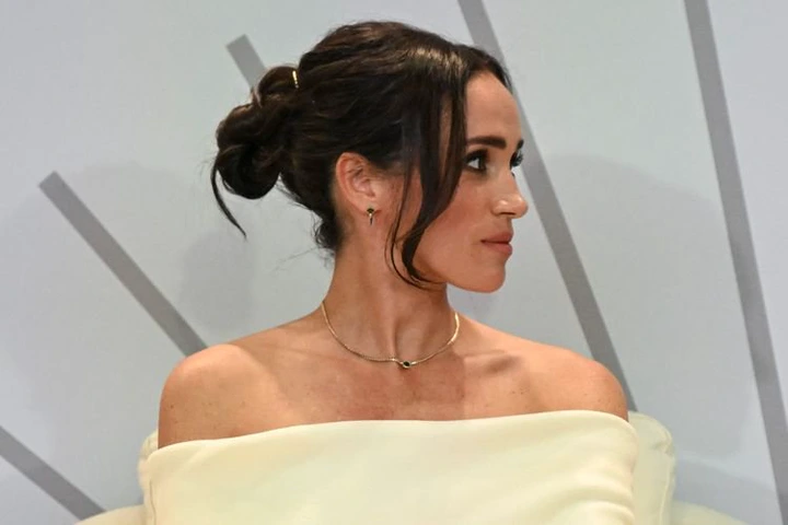 Meghan Markle with a gold necklace and a bun