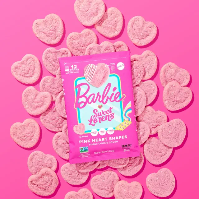 Heart-shaped cookies surrounding a Barbie Sweet Lovers cookie dough package on a pink background