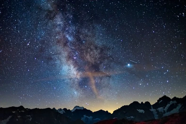 The Milky Way arch starry sky on the Alps, Massif des Ecrins, Briancon Serre Chevalier ski resort, France. Panoramic view high mountain range and glaciers, astro photography, stargazing