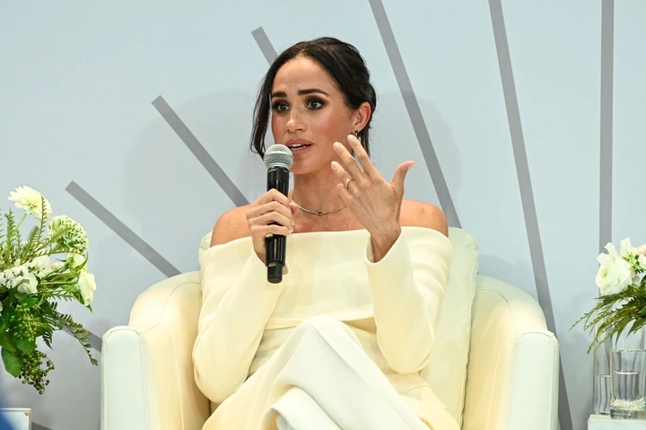 Meghan Markle speaking on stage in white