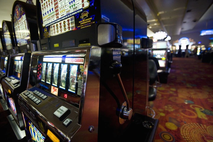 Slot machines lined up in a casino with vibrant patterned carpet, capturing the atmosphere of gaming and leisure related to financial topics