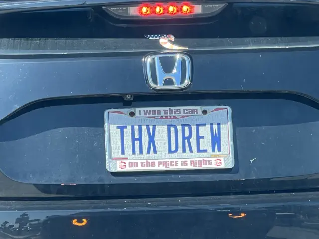 License plate reads &quot;THX DREW&quot; with text above and below saying &quot;I won this car&quot; and &quot;on the Price is Right.&quot;