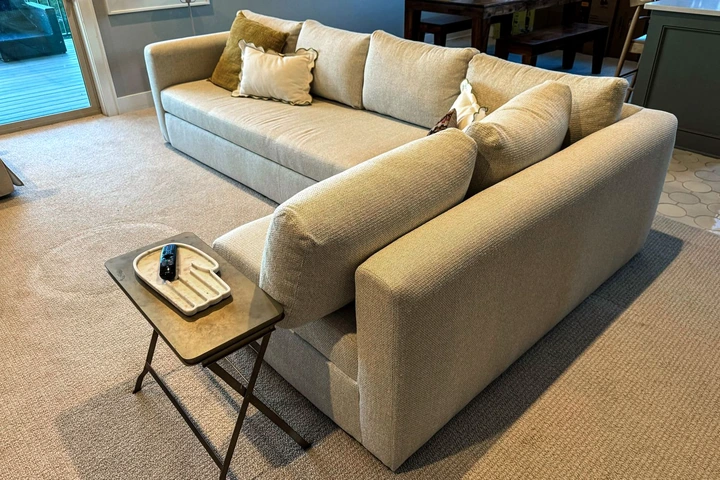 The Room & Board 90 Inch Pop-Up Platform Queen Sleeper Oxford Sectional in a living room