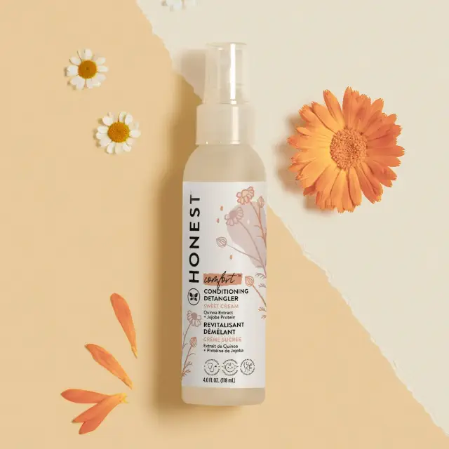 Bottle of Honest Conditioning Detangler on a beige background with floral accents, promoting hair care in a shopping article