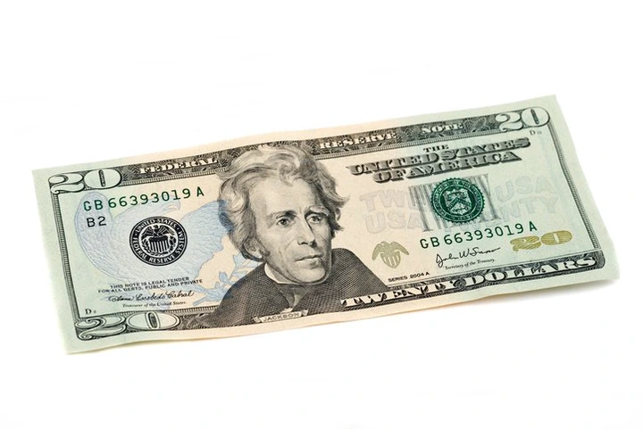 A U.S. twenty-dollar bill featuring a portrait of Andrew Jackson, with visible serial numbers